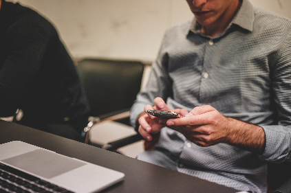 Man On Computer Using Phone